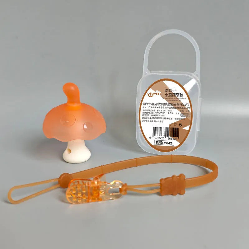Small mushroom-shaped silicone chewing gum on a chain, in pink or nano colour, inside a transparent box.