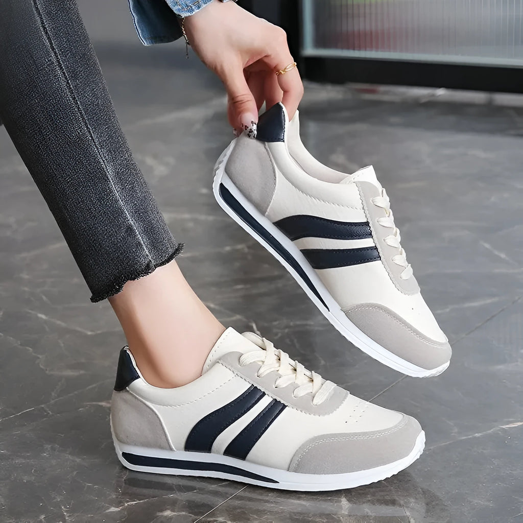 Low-top blue and red lace-up sneakers with mesh upper and rubber sole on a white background