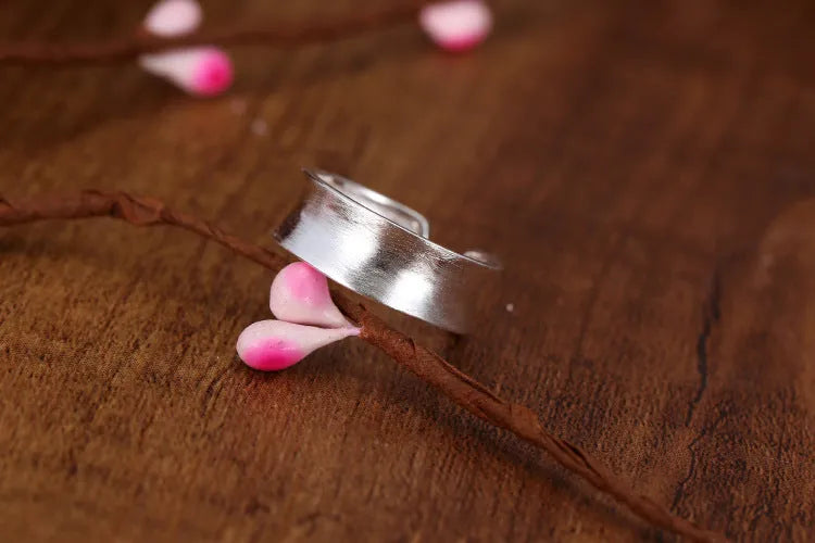 Frosted silver geometric open ring with adjustable sizing on a neutral background