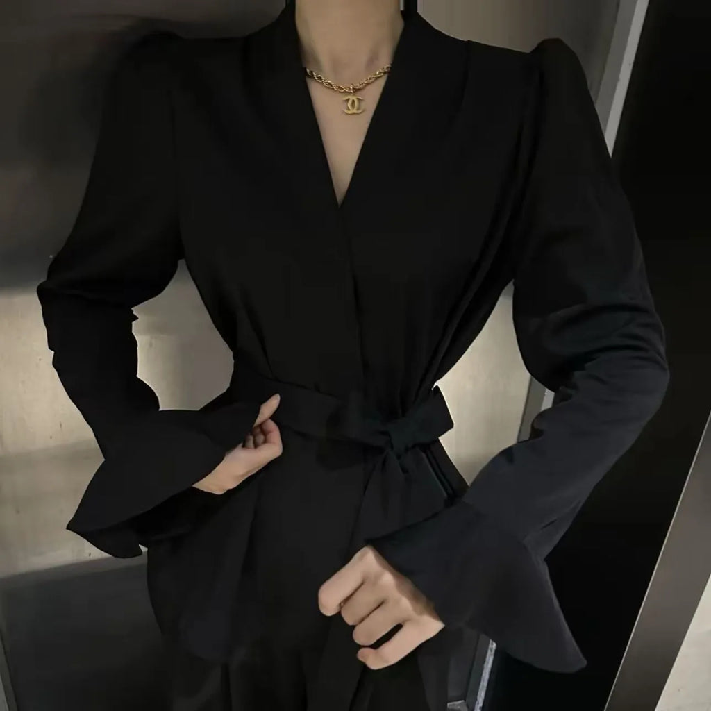 Women's black French-style shirt with irregular collar, long bell sleeves, and a tied front detail.
