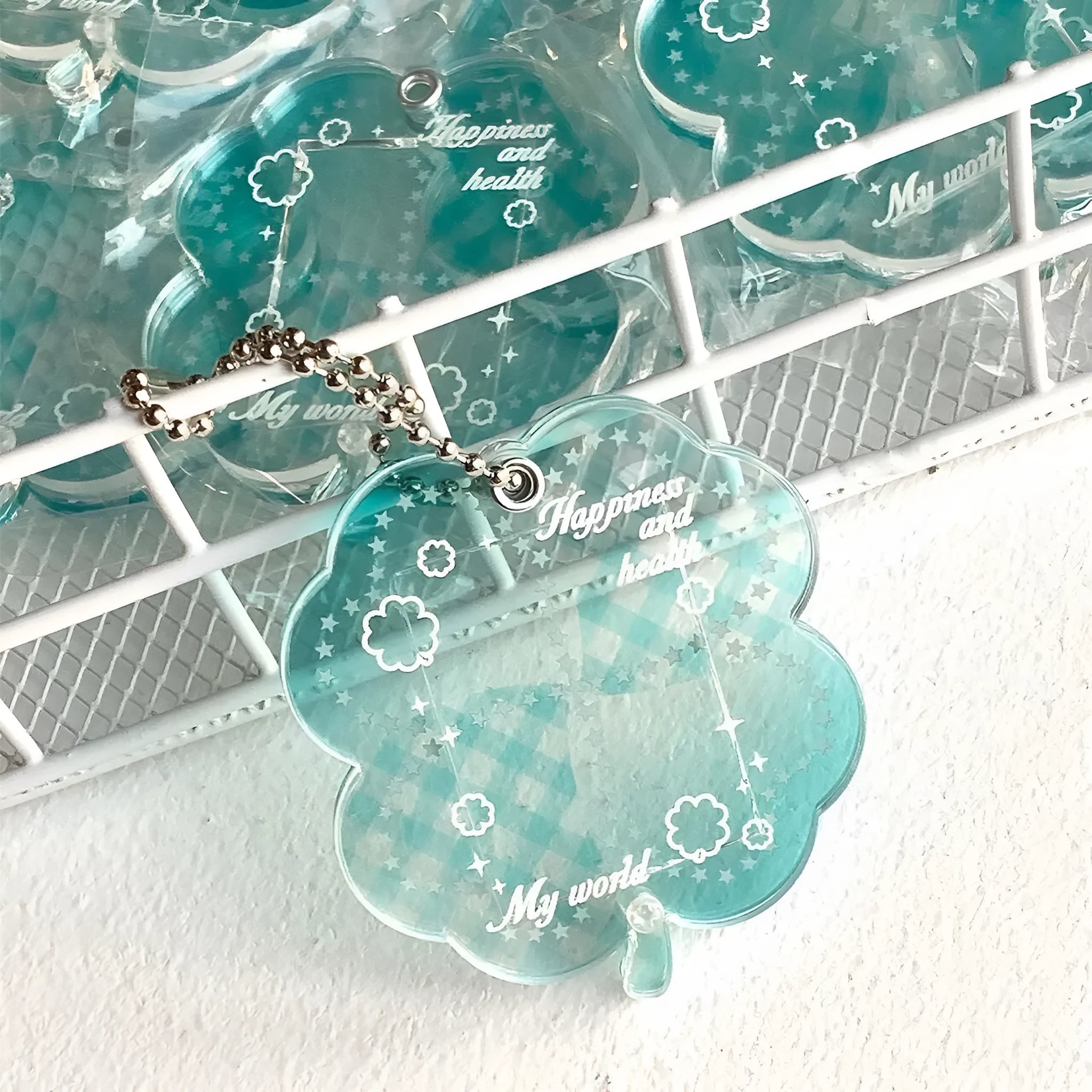 Acrylic four-leaf clover phone pendant keychain on a ring in blue, green, or mint.