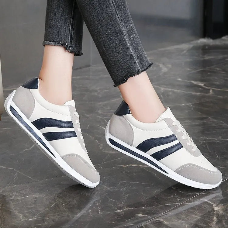 Low-top blue and red lace-up sneakers with mesh upper and rubber sole on a white background