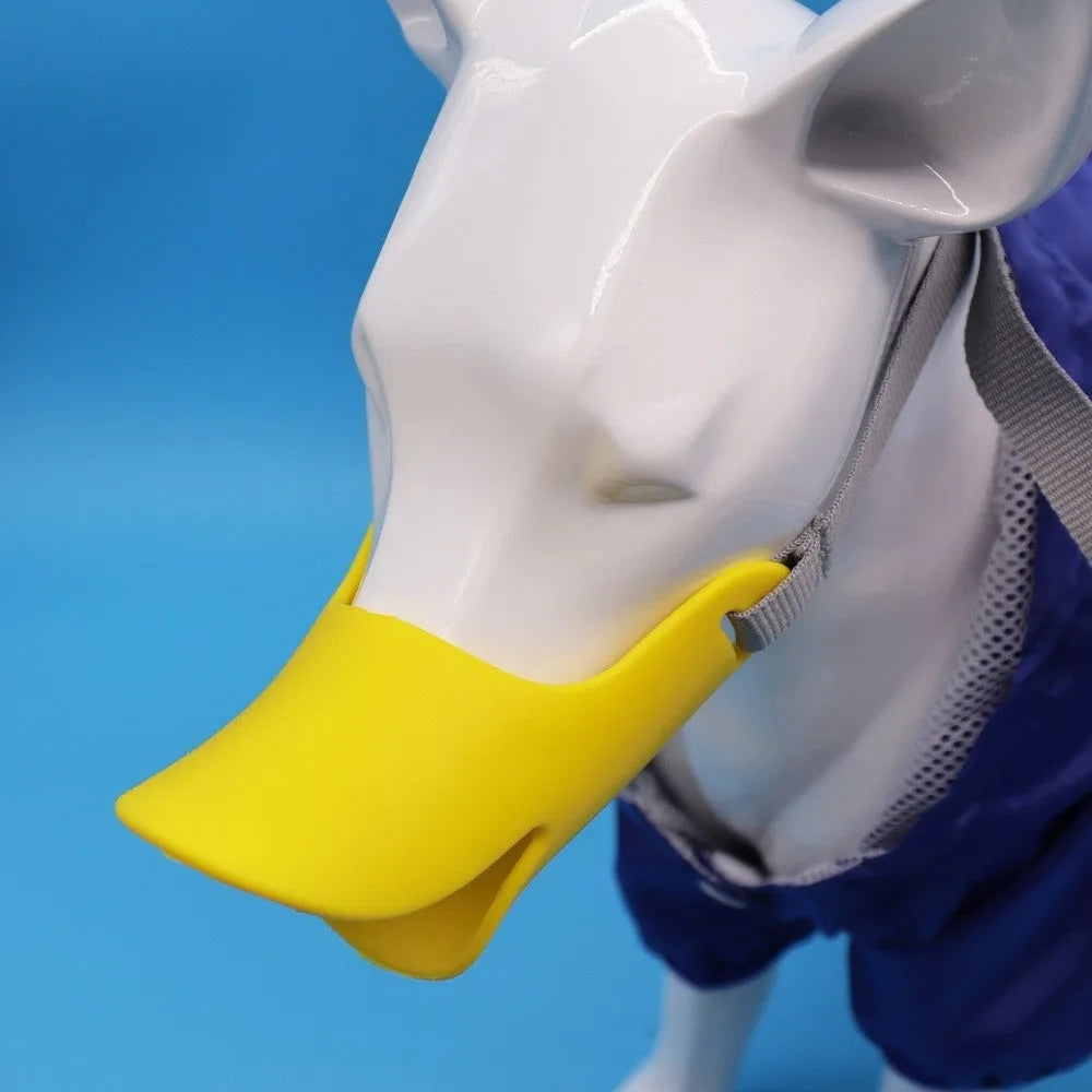 Silicone duckbilled dog muzzle in yellow on a small dog with adjustable strap