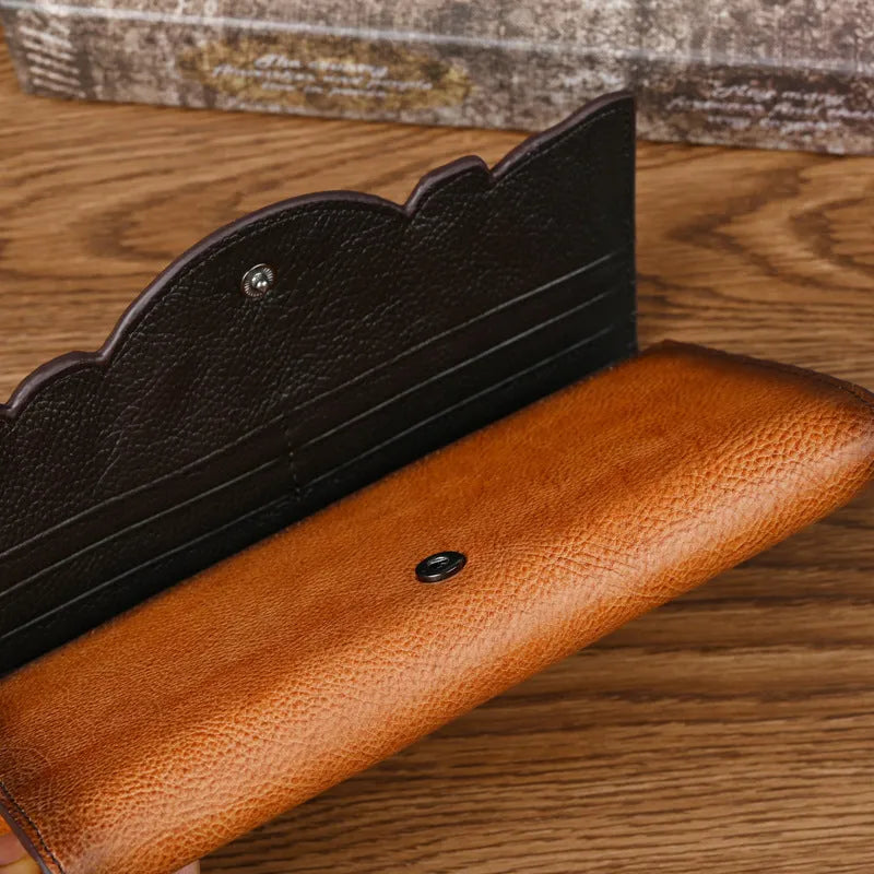 Women's brown tri-fold leather wallet with embossed floral pattern showing open compartments