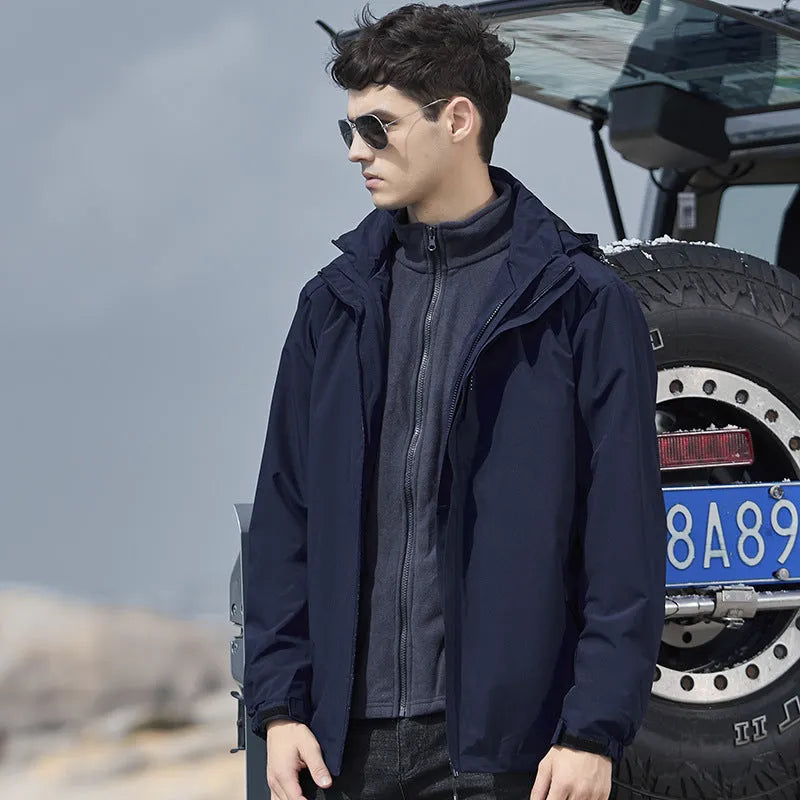Man wearing a black waterproof mountaineering suit jacket and trousers set for outdoor hiking.
