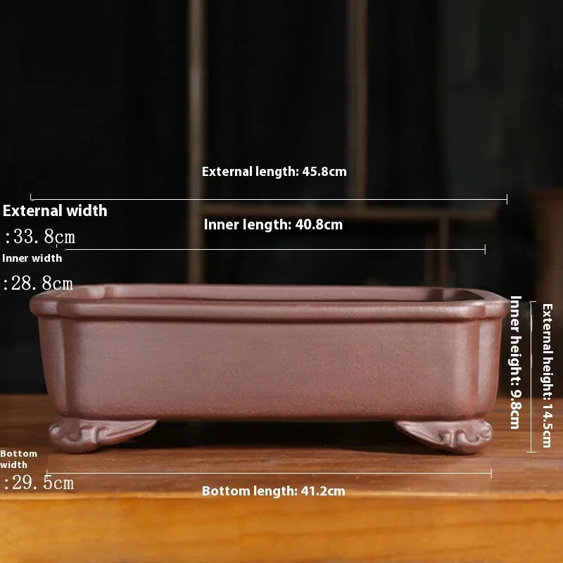 Rectangular antique purple sand bonsai planter with corner-cut design on floor.