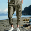 Man wearing khaki linen casual trousers with ankle-tied legs and multiple pockets.