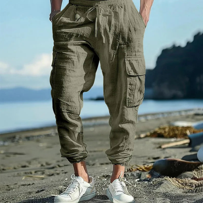 Man wearing khaki linen casual trousers with ankle-tied legs and multiple pockets.
