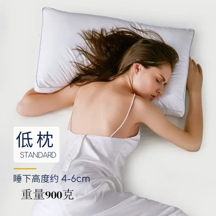 White cotton satin stripe pillow with feather and cotton filler on a bed.
