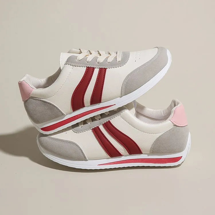 Low-top blue and red lace-up sneakers with mesh upper and rubber sole on a white background