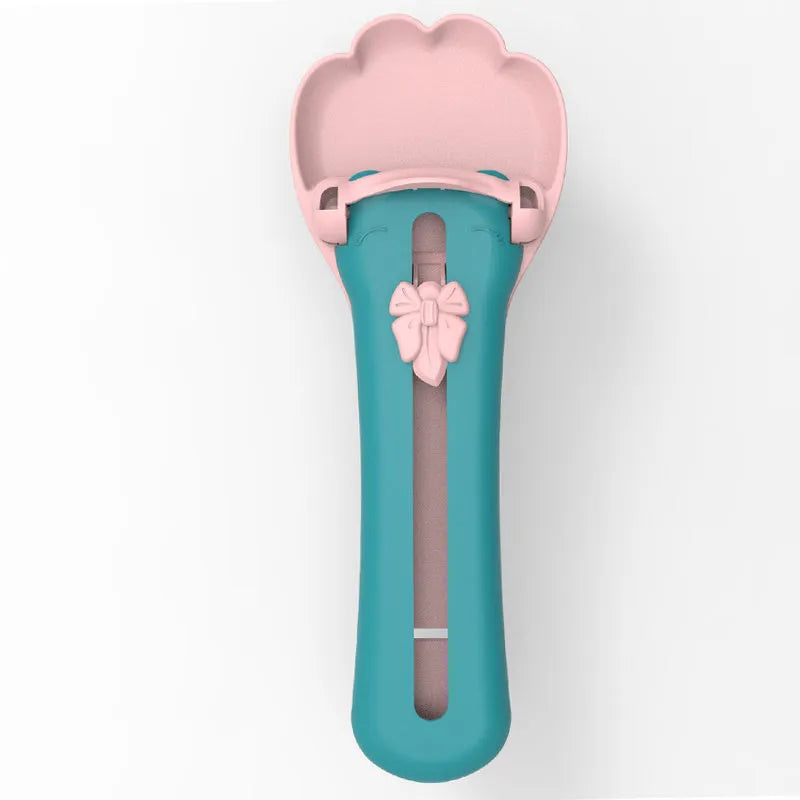 Pink and green pet feed spoon with squeezer mechanism for wet food and treat dispensing