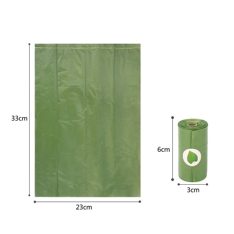 Roll of green EPI degradable dog poo bags next to a white plastic dispenser on a grass background.