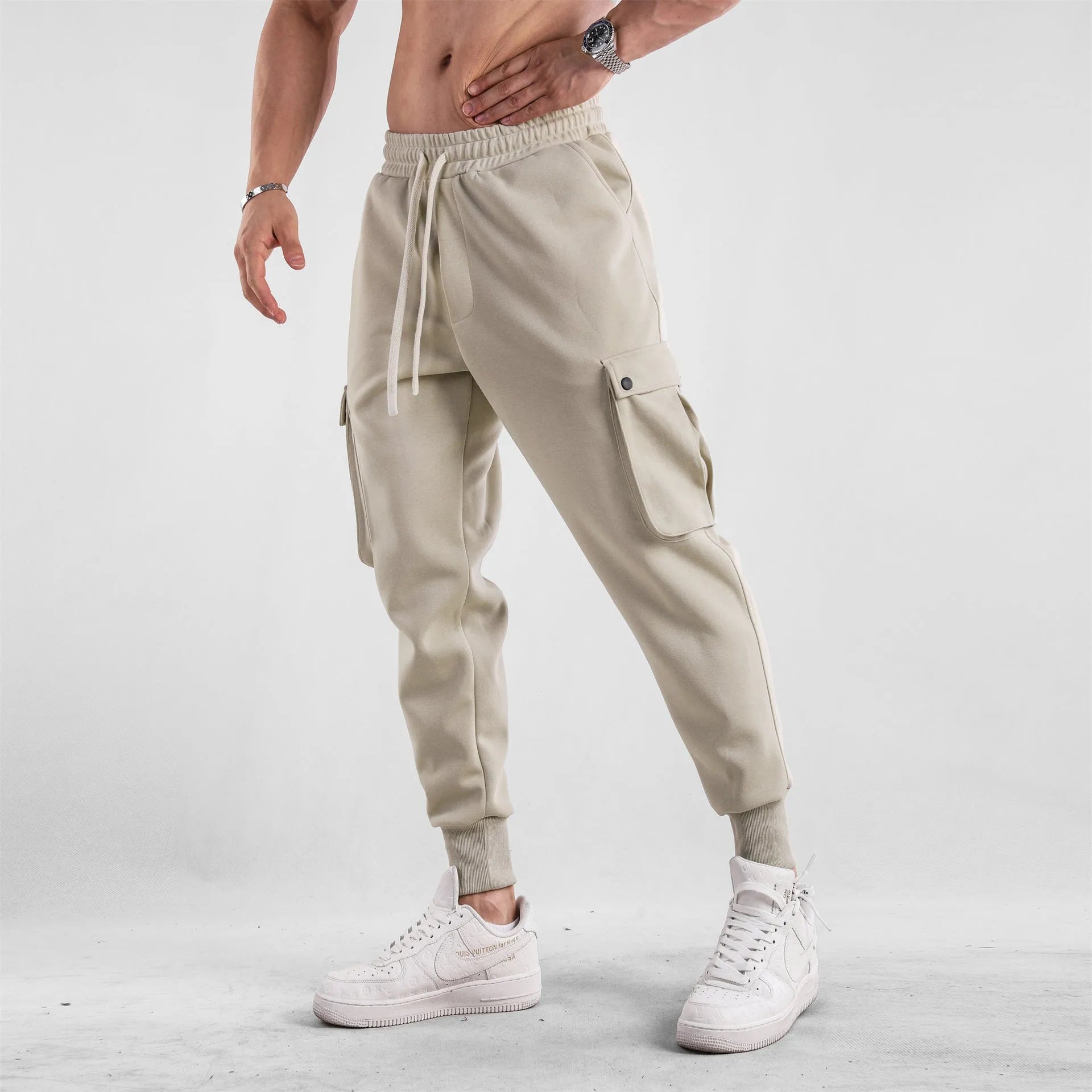 Men's loose-fit light grey cotton sports trousers with ankle tie and side pockets.