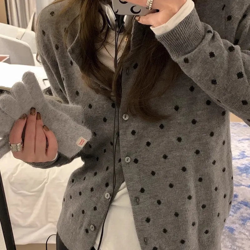 Women's grey dot pattern knitted cardigan with crochet flower details on sleeve.