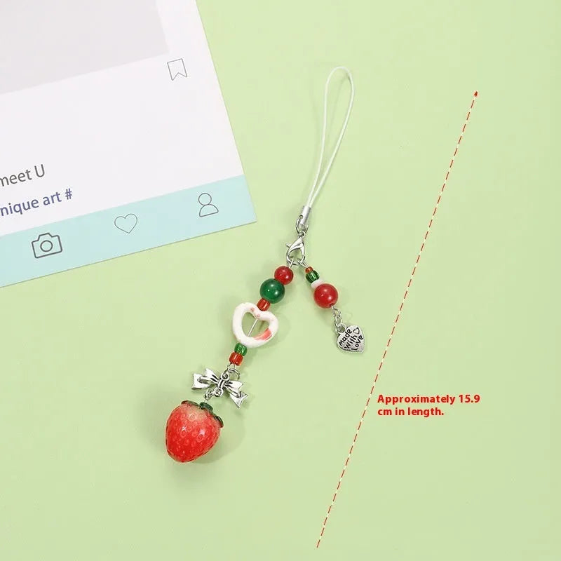 Plastic resin fruit phone charm keychain with strawberry design on white rope cord