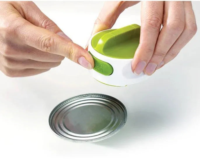 Compact manual can opener with stainless steel blade and ABS plastic body on a kitchen counter