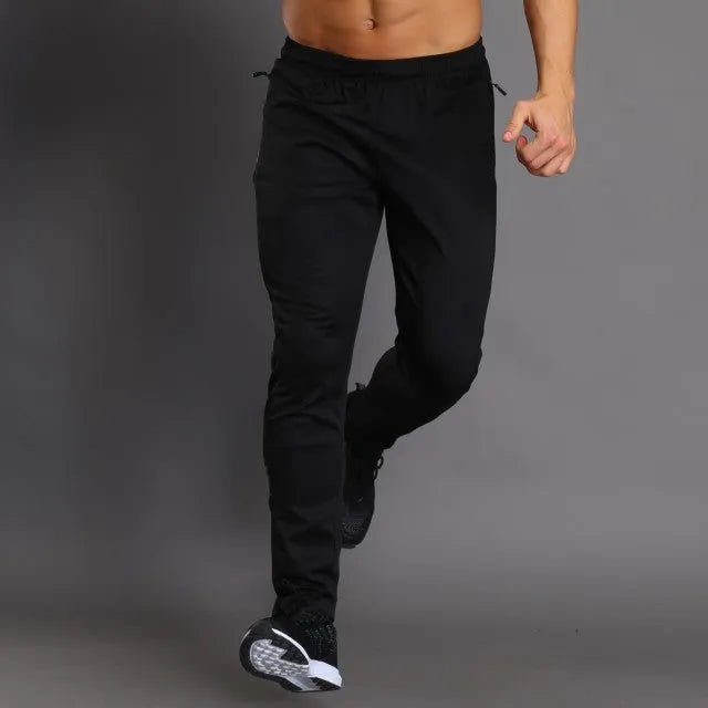 Slim-fit polyester running trousers with colour-changing reflective printing and zip pocket, black, front view