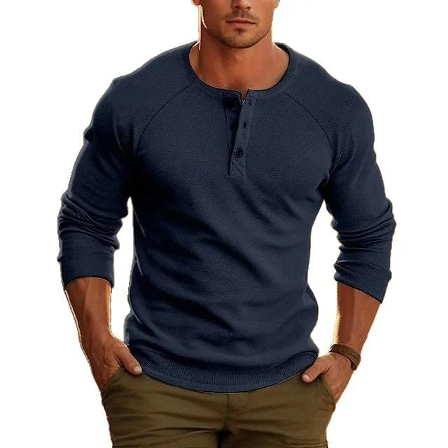 Man wearing a navy blue long-sleeved t-shirt with a Henry collar.