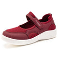 Women's low-top grey mesh sneakers with Velcro straps on a flat polyurethane sole.