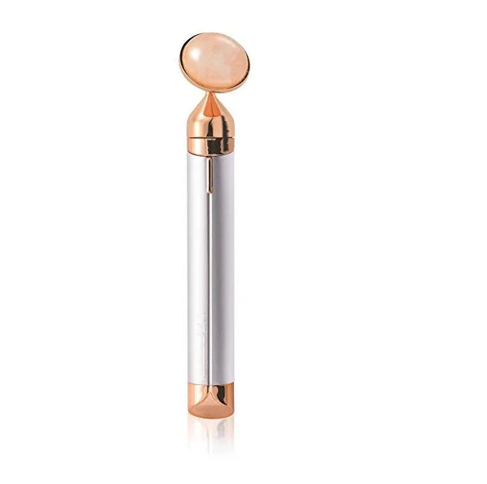 Electric vibrating rose quartz facial roller with under eye press on pink background