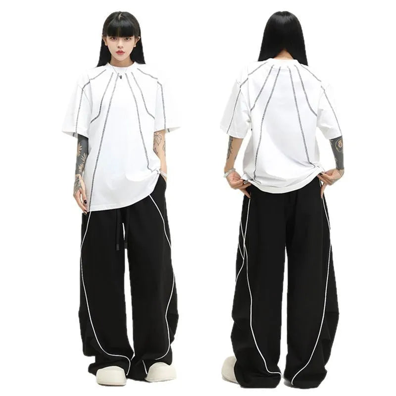 Black pleated wide-leg hip hop sports trousers on a hanger, showing loose fit and striped pattern.