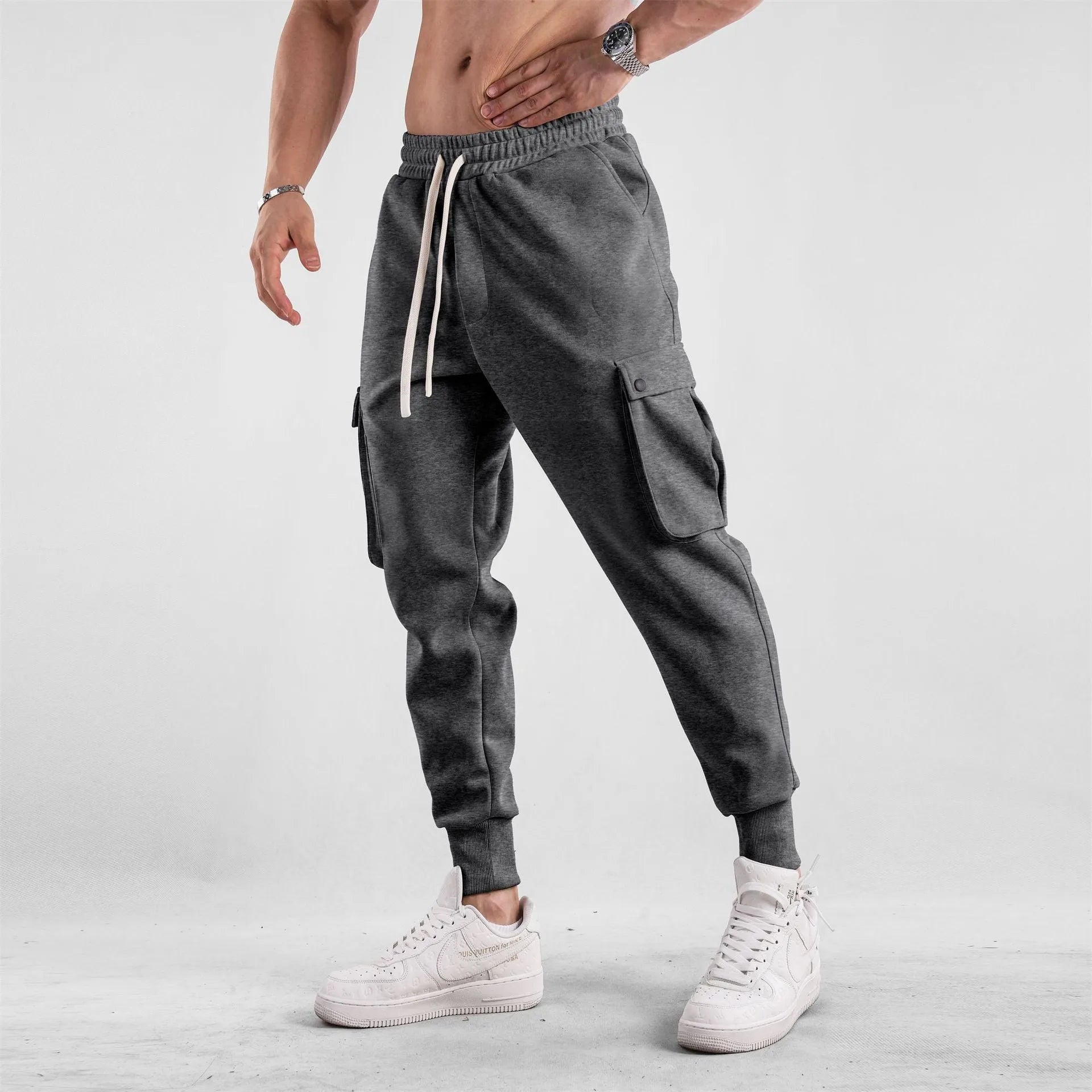 Men's loose-fit light grey cotton sports trousers with ankle tie and side pockets.