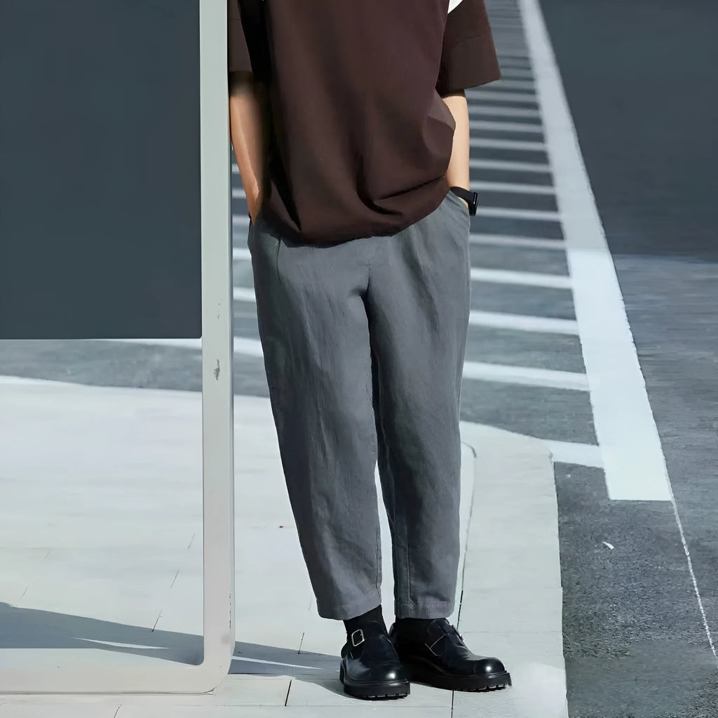 Man wearing beige loose straight leg casual trousers with a drawstring waistband.