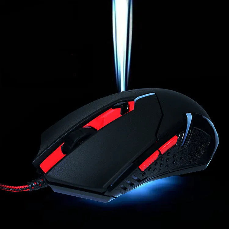 Black and red wired USB gaming mouse with six buttons on an office desk.
