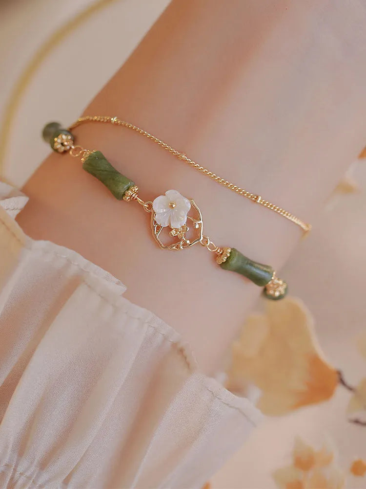Natural olivine gemstone bracelet for women with double layer design and twin bells of Ireland charms.
