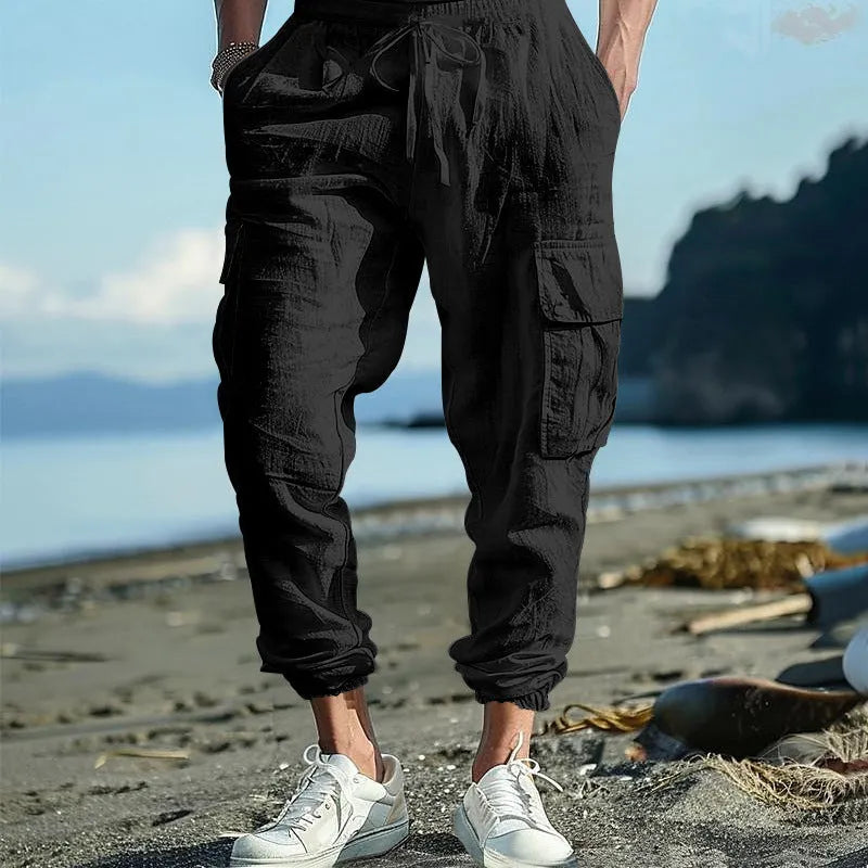 Man wearing khaki linen casual trousers with ankle-tied legs and multiple pockets.