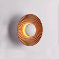 Round aluminium LED wall lamp in a dual-colour finish mounted on a wall.