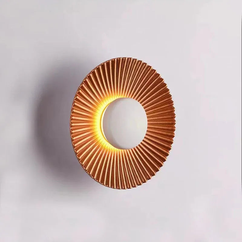 Round aluminium LED wall lamp in a dual-colour finish mounted on a wall.