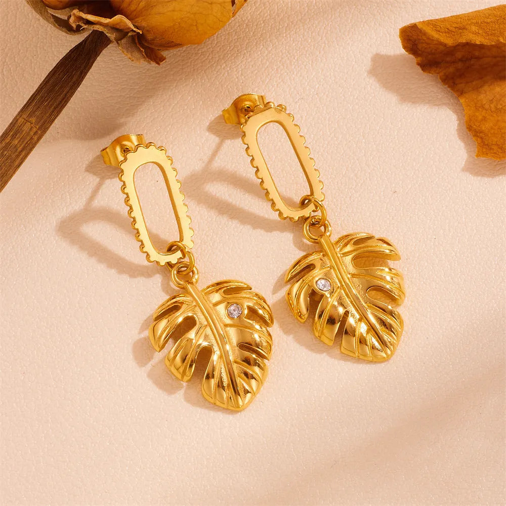 Heart shape titanium steel earrings in gold leaf style on white background