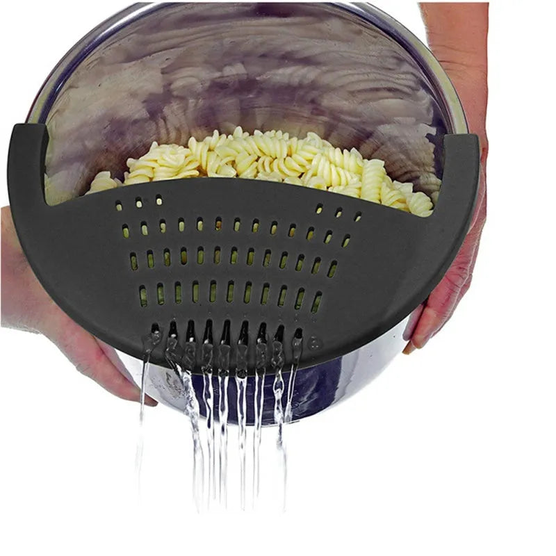 Black silicone food oil drainer snapped onto a pot rim, with liquid being poured off