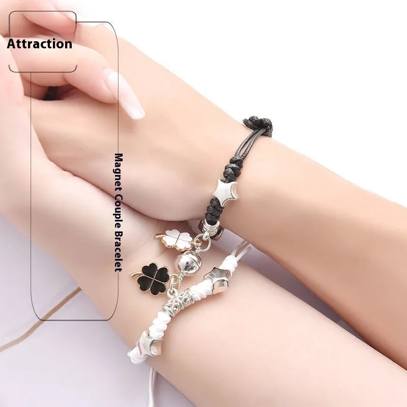 Pair of magnetic suction bracelets with alloy charms in various love and friendship themed designs on a wrist.