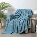 Shu Cotton Velvet Jacquard blanket in fog blue with a woven plant flower pattern, laid flat.