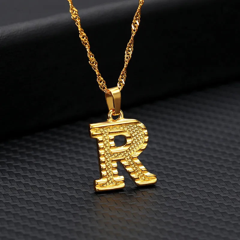 Gold-plated alloy initial pendant necklace with 42cm chain on white background