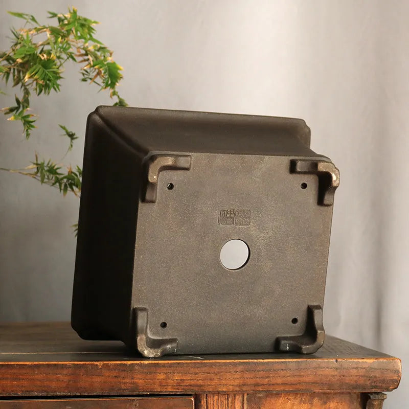 Purple sand square high basin flower pot with black ancient copper clay finish on a wooden table