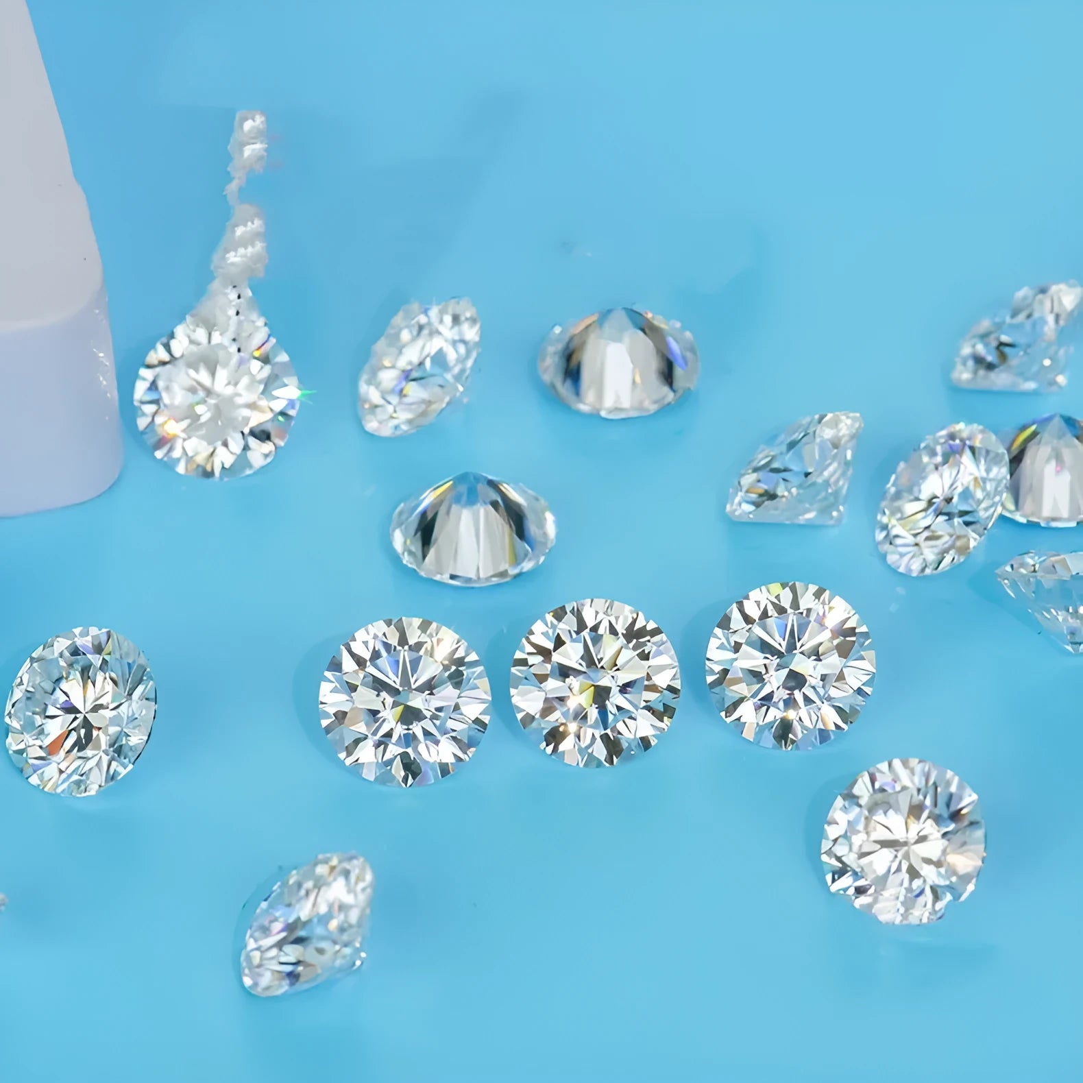 Round loose moissanite gemstone with eight hearts and eight arrows cut on a white background.