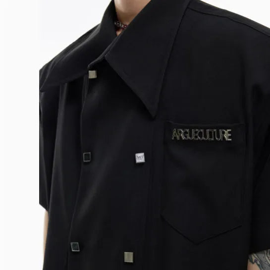 A man's loose-fit casual short-sleeved shirt in a blue colour with a lapel collar and decorative splicing details.