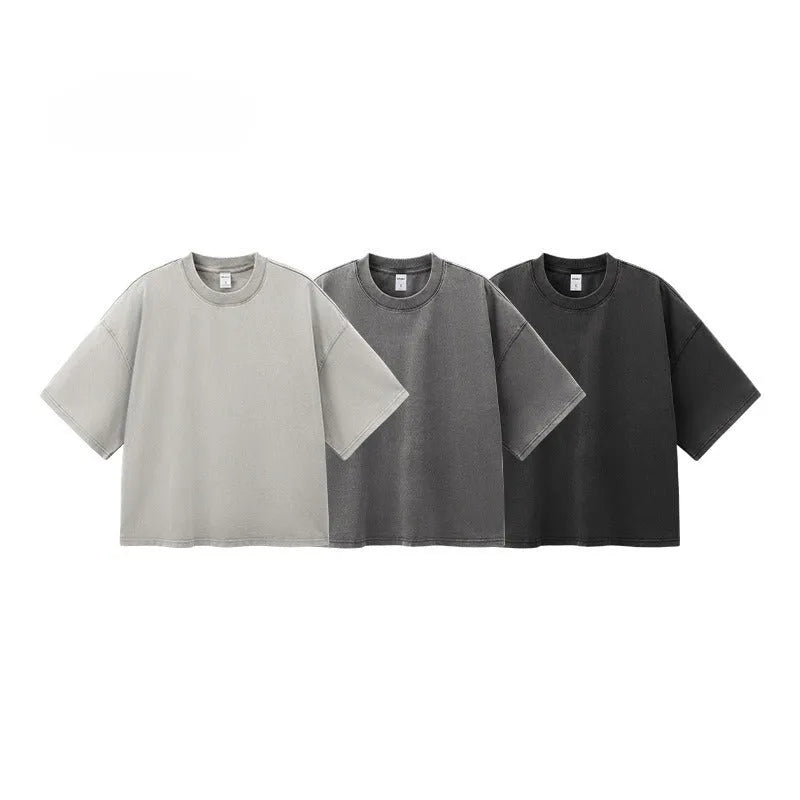 Men's vintage-style light khaki cotton t-shirt with a loose fit and drop-shoulder sleeves on a hanger.