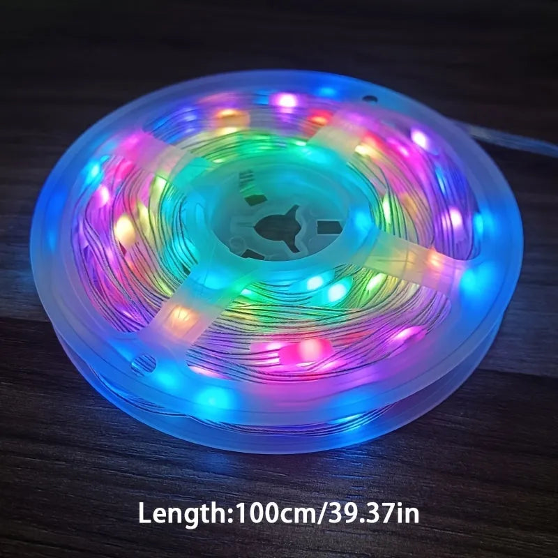10 metre long multicolour LED party light string with 100 lights coiled on a table next to its control switch.