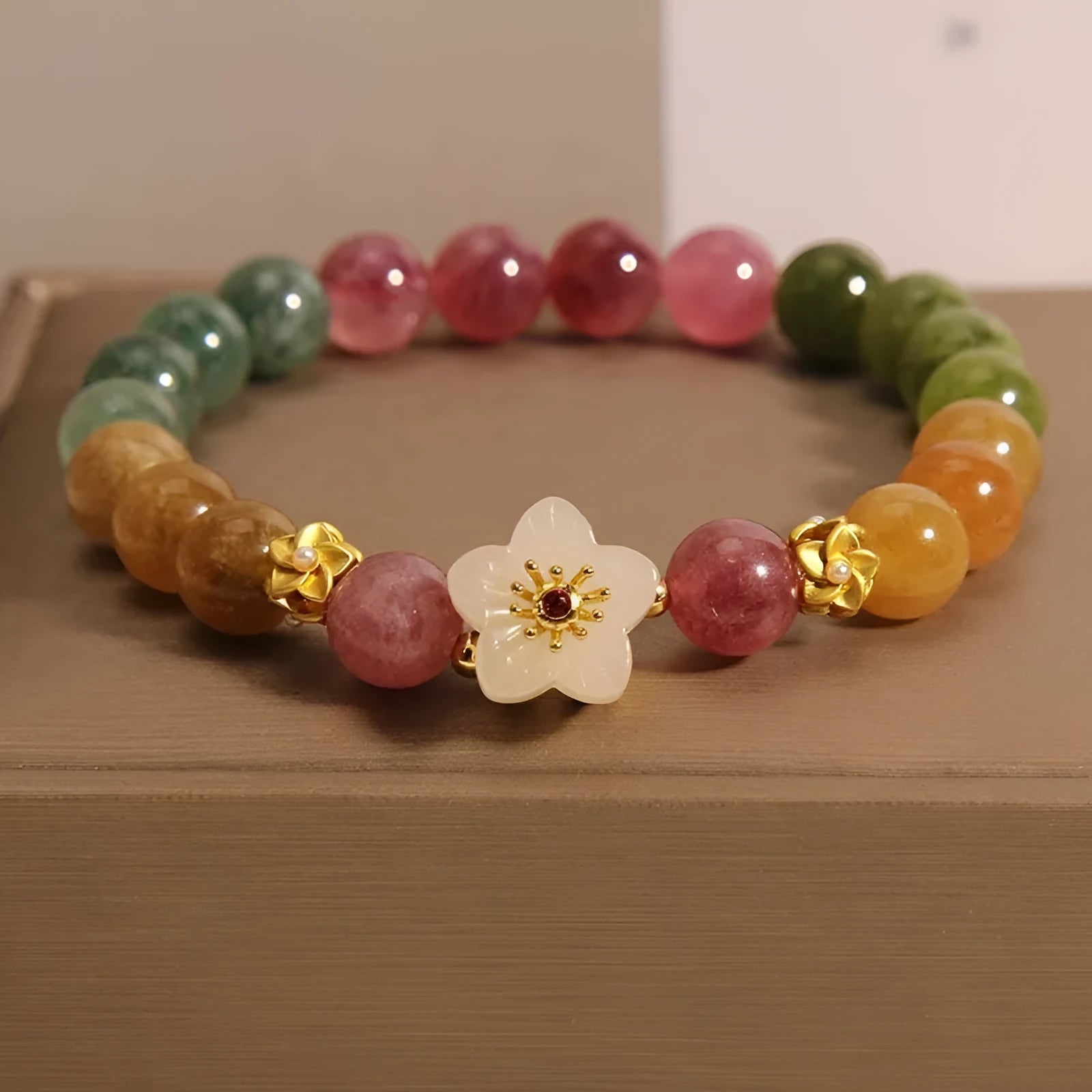 Natural colour tourmaline bracelet with floral and fu character charms on geometric electroplated chain
