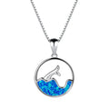 Close-up of a white gold plated sea fishtail pendant necklace with a round blue opal stone.
