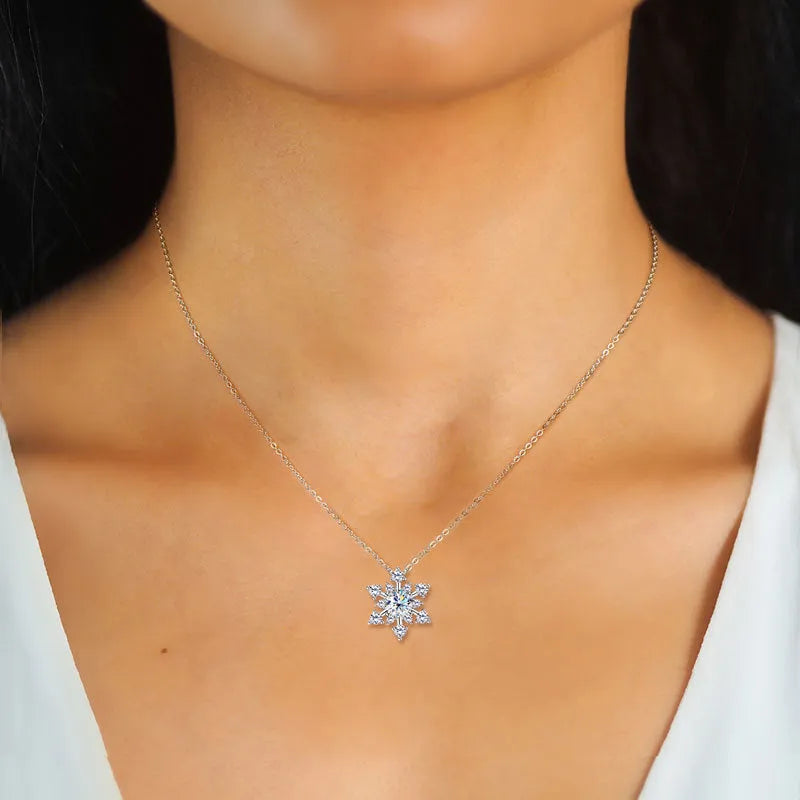 Gold snowflake moissanite pendant on silver 925 O-ring chain against white background