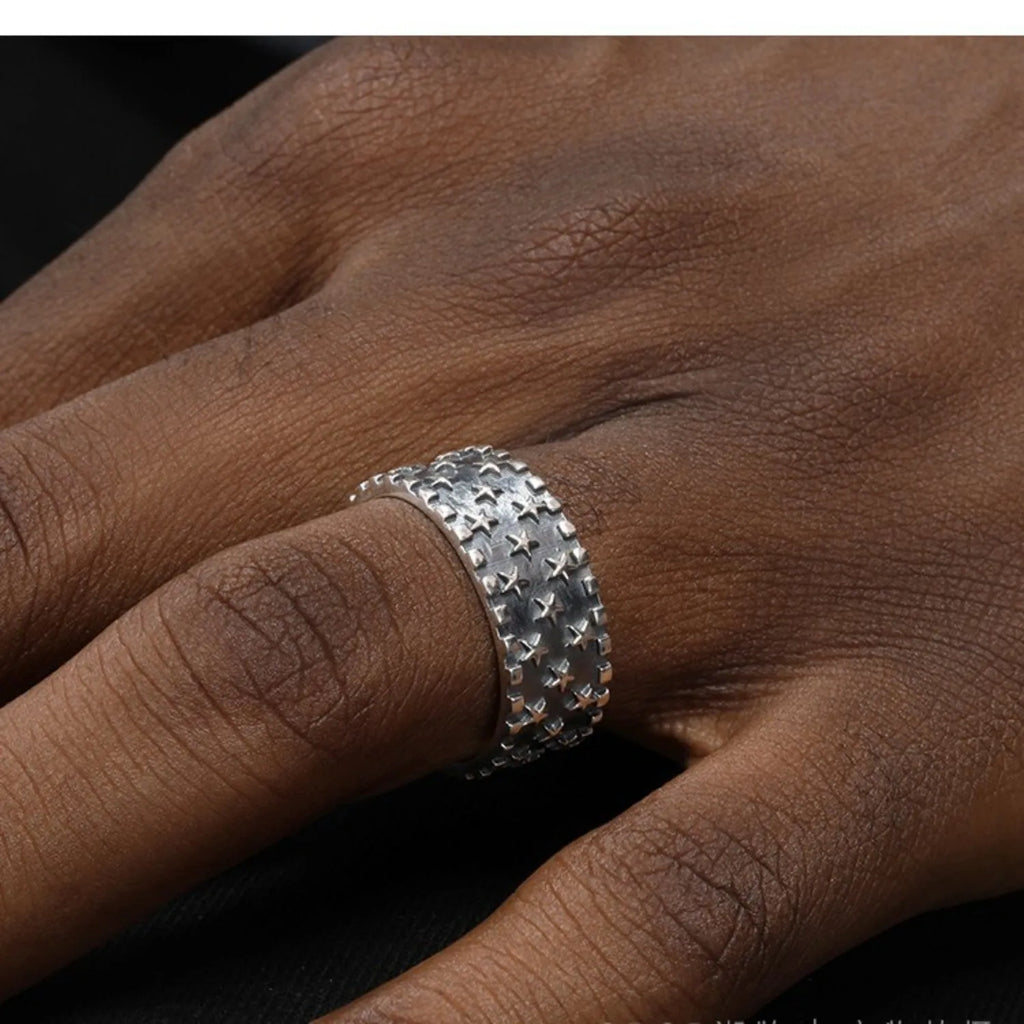 Adjustable sterling silver ring with a geometric five-pointed star pattern on a plain background.