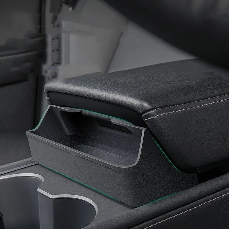Black silicone glasses case mounted on a Tesla Model 3 or Y central armrest.
