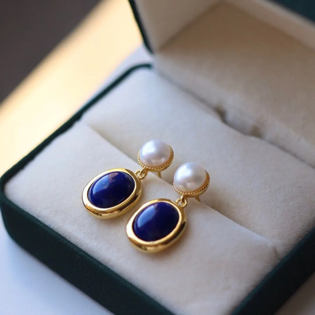 A pair of simple sterling silver drop earrings with a blue lapis lazuli pearl and auspicious patterns.