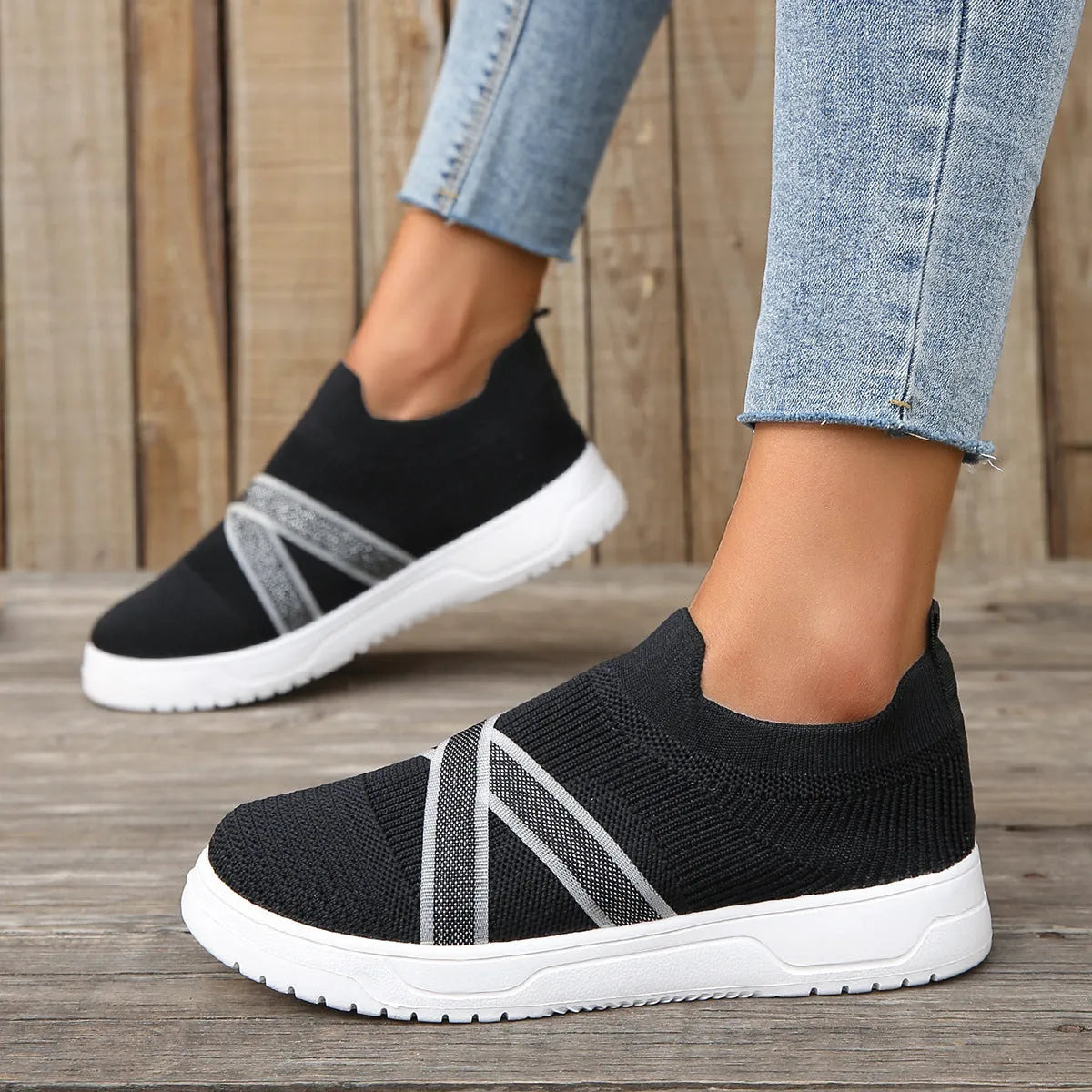 Black women's low-top flyknit mesh shoes with flat rubber sole and tassel detail.
