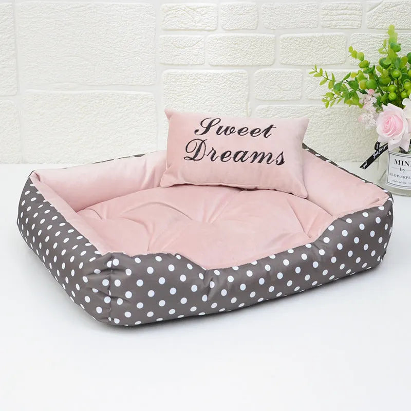 Polka dot print dog bed with matching embroidered cushion in grey, shown in a home setting.